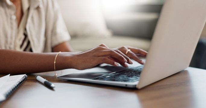 Person skriver på en bärbar dator vid ett skrivbord